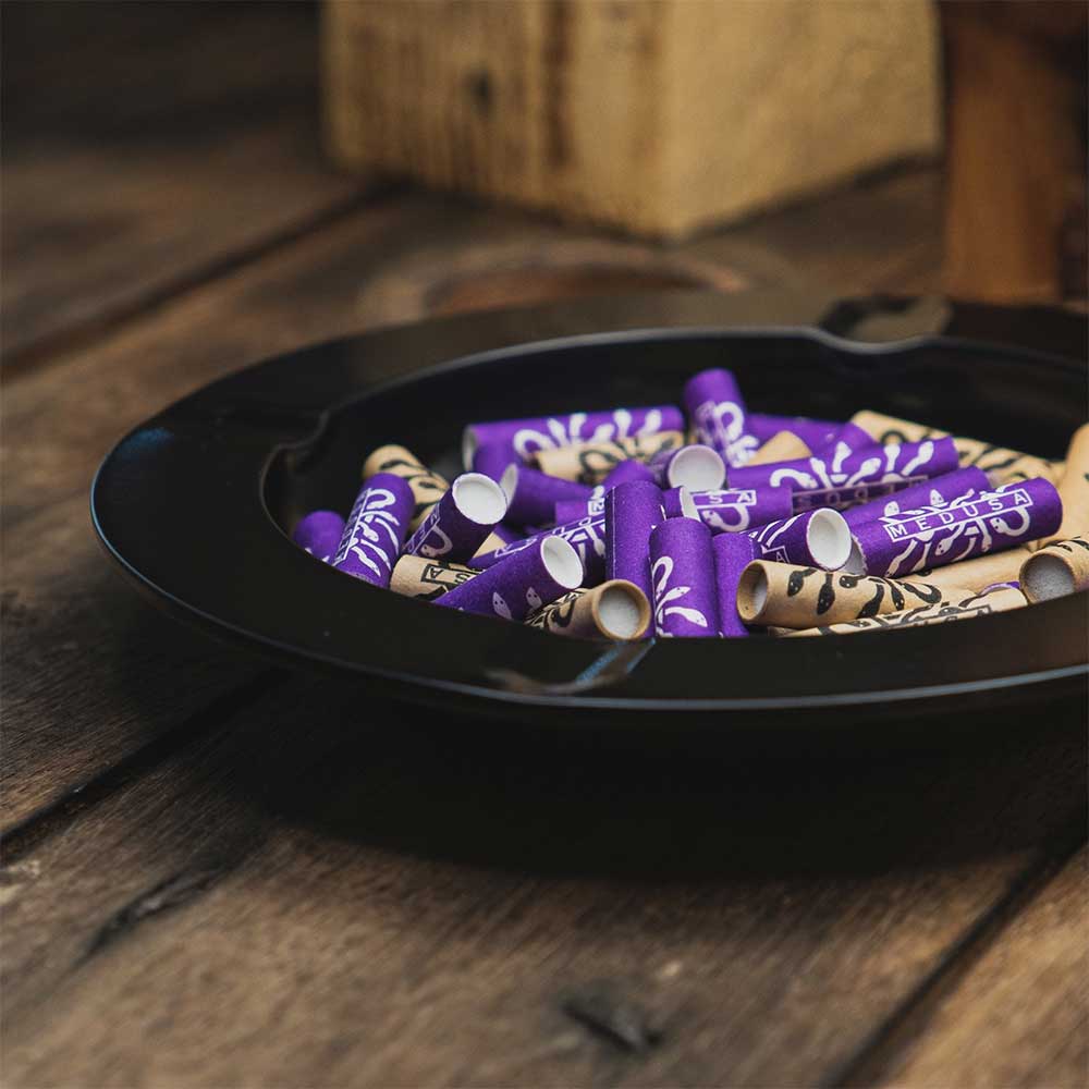 Medusafilters Aschenbecher BLACK auf Holz, gefüllt mit Aktivkohlefiltern in VIOLET und ORGANIC