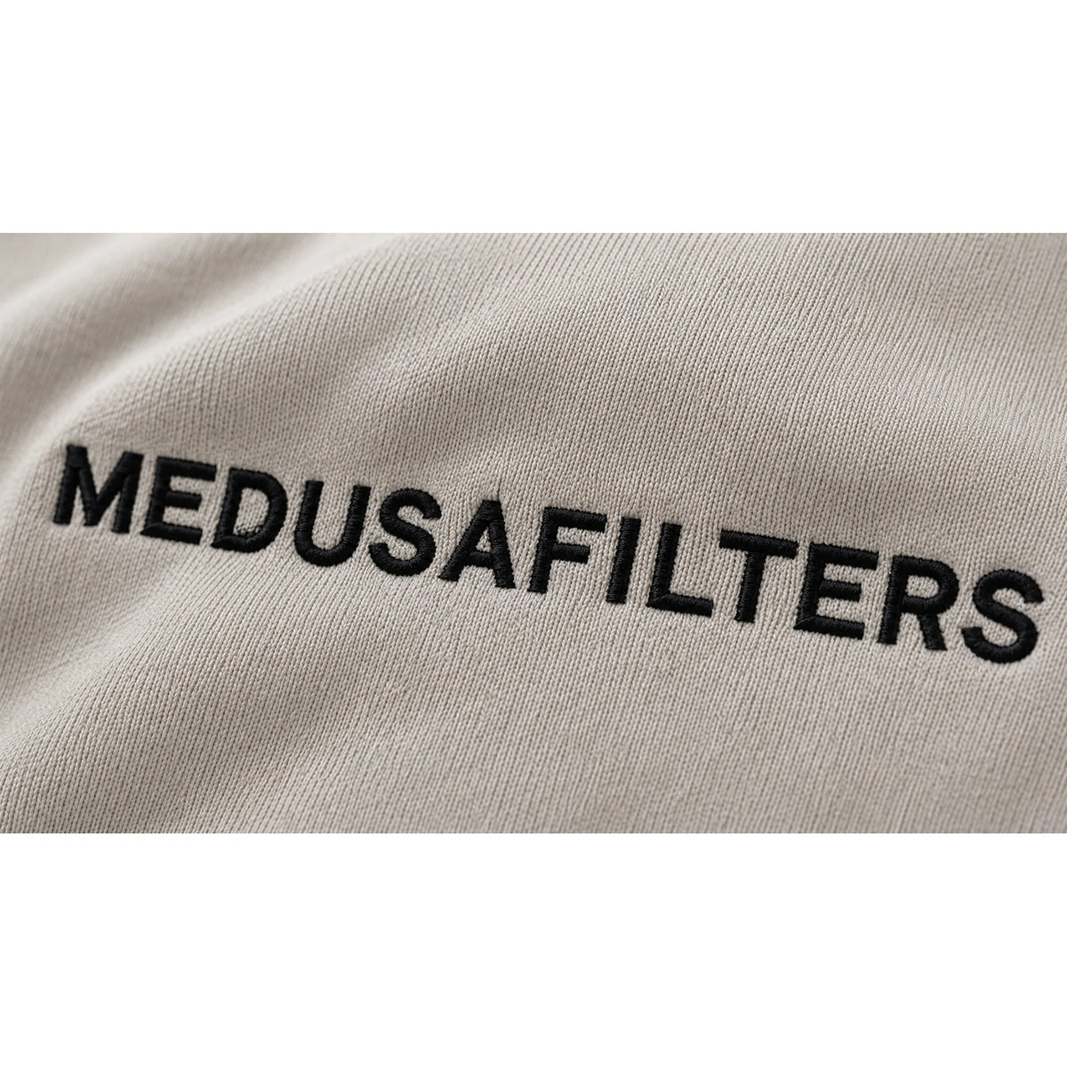 Gestickter Medusafilters Schriftzug auf dem T-Shirt Beige, Nahaufnahme